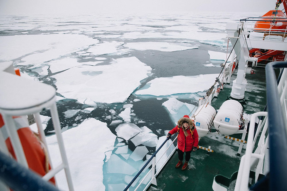 Landscape image of Liz Carlson on a boat in the artic