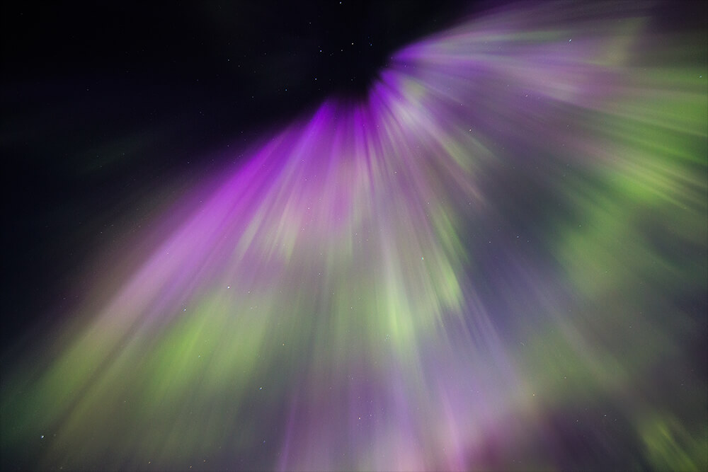 photography of the Northern Lights with purple tones. Shot by Neil Bloem