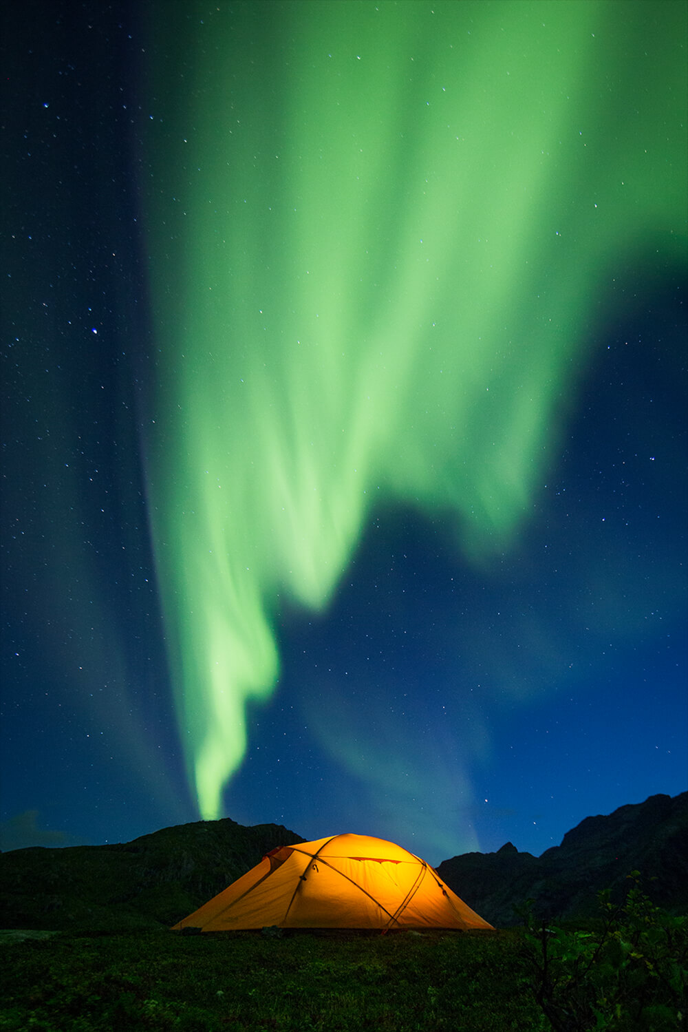 photo of a camping tent under the Northern Lights. Image by Neil Bloem