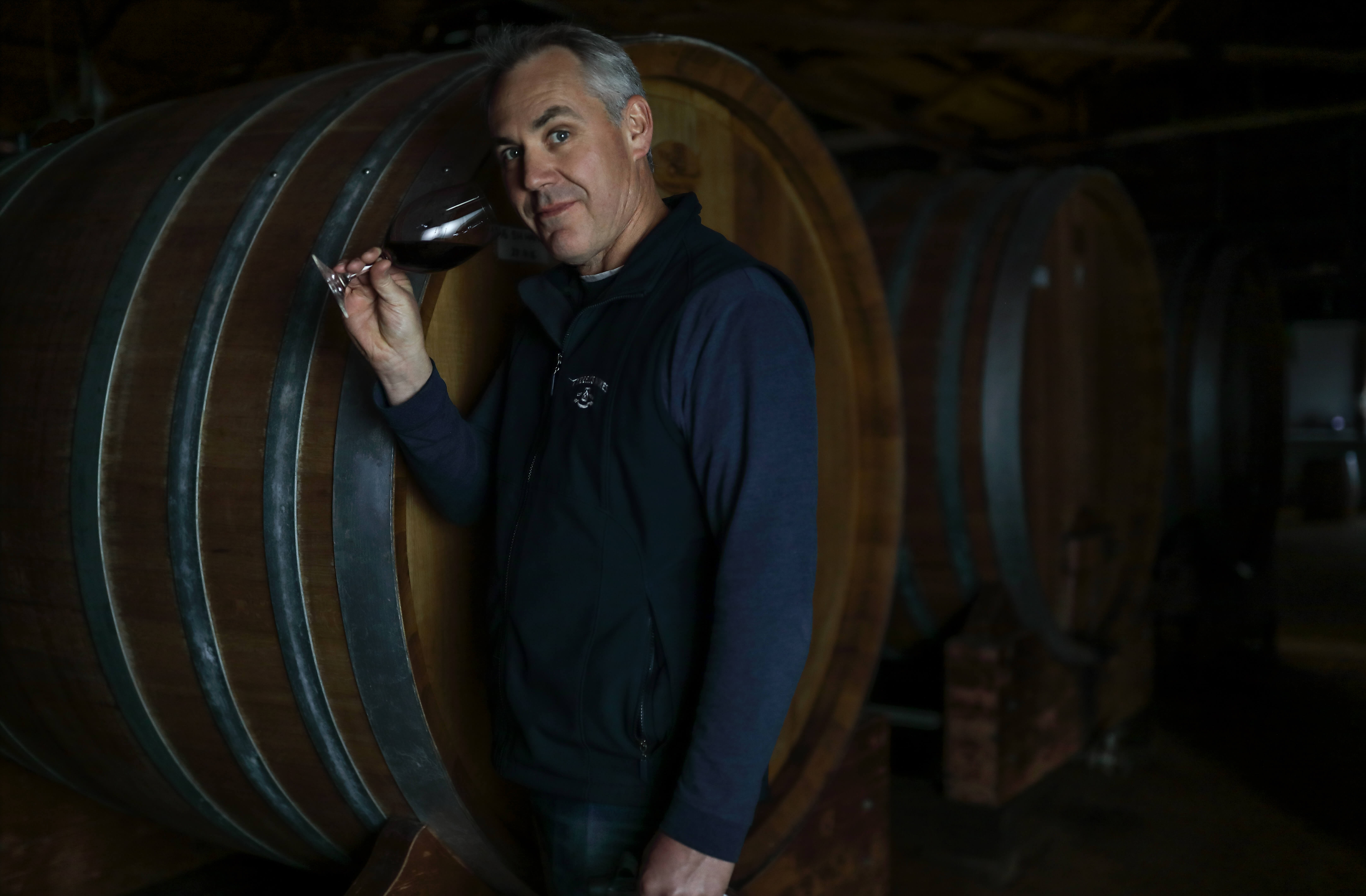 Portrait of winemaker in low light.
