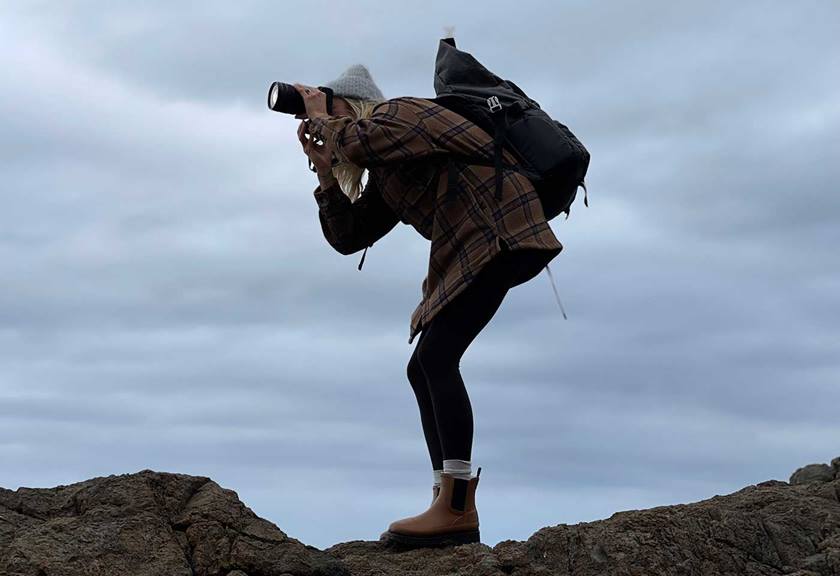 Image of Amber Jones with a backpack on photographing something