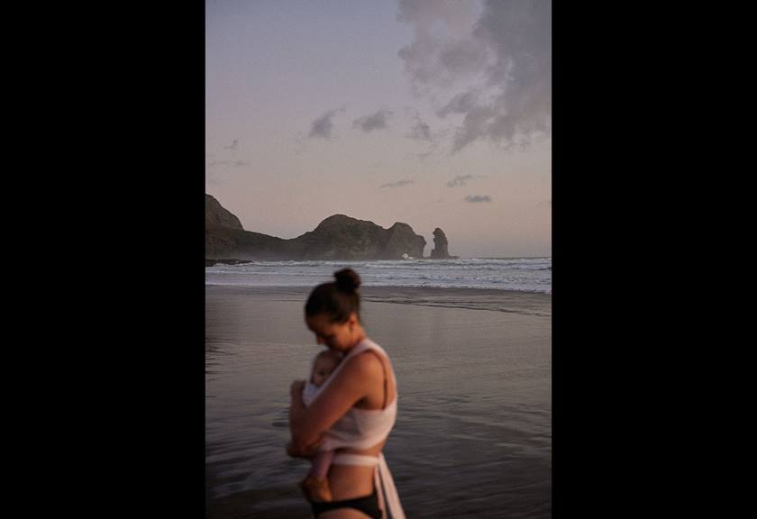 Image of a woman holding her child by the beach