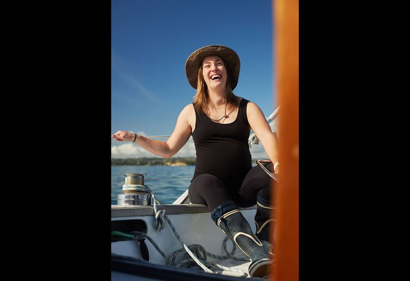 Image of a pregnant lady laughing on a boat