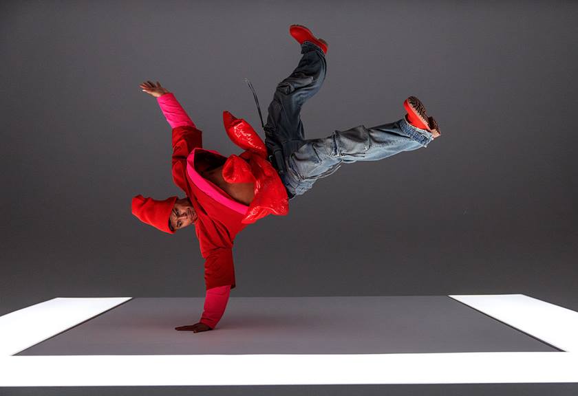 Image of a dancer in red outfit doing a break dance move