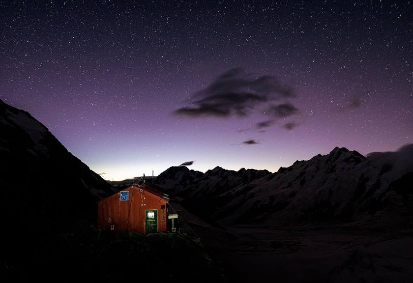 Red cabin dimly lit in the dark night sky