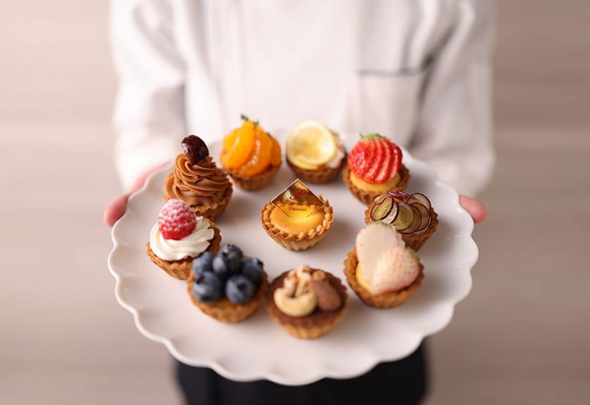 Image of different kinds of tarts presented on a plate by a chef