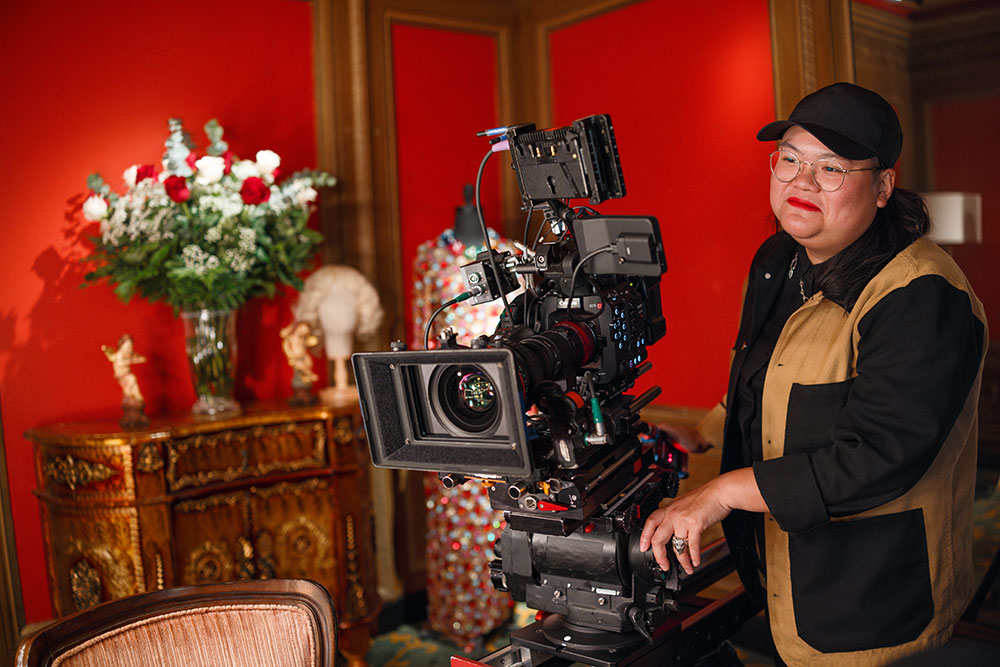 Women with headset operating big camera and lens on a tripod, ready to capture a moment