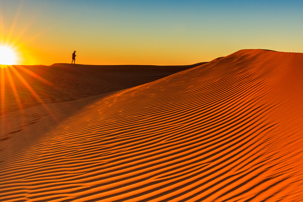 Man on top of a sand dune