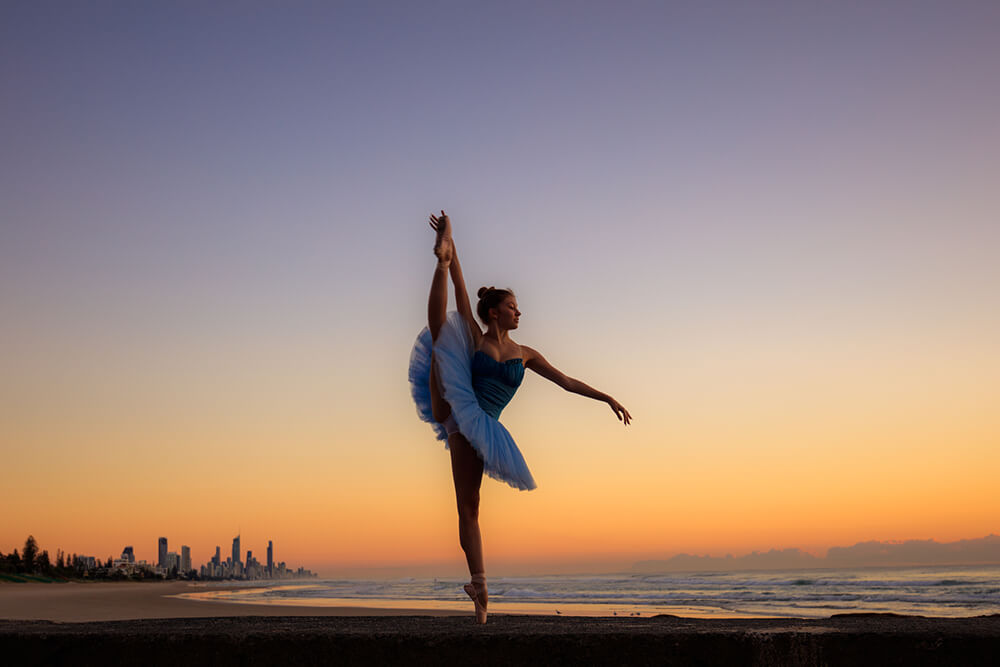 Ballerina dancing on the beach at sunset