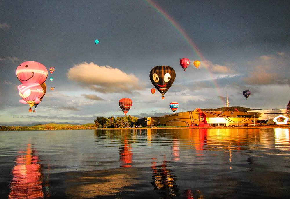 Hot air balloon at sunrise with rainbow