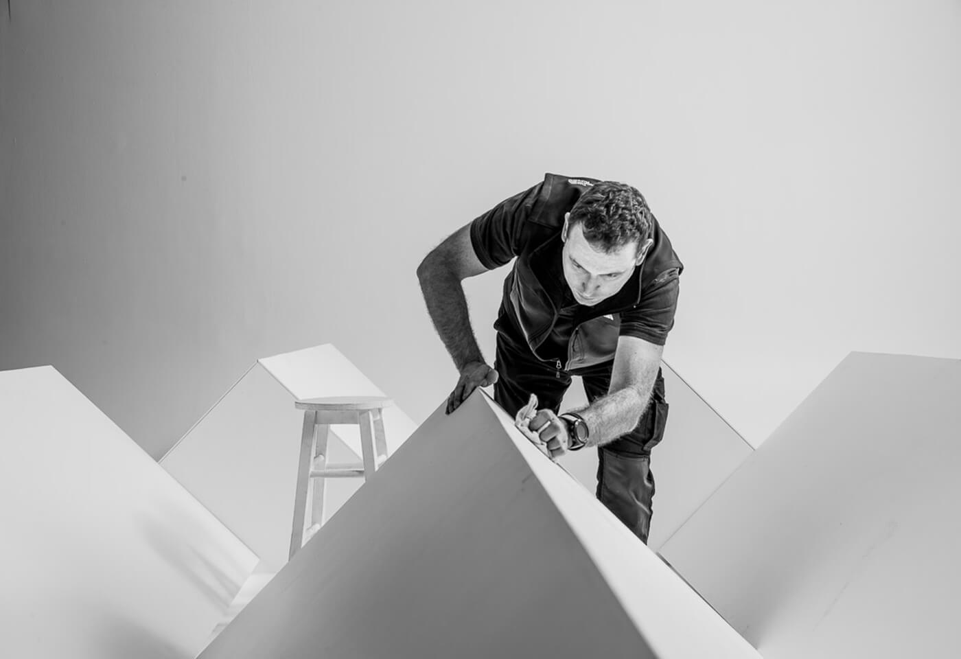 Black and white photo of photography assistant preparing props in studio
