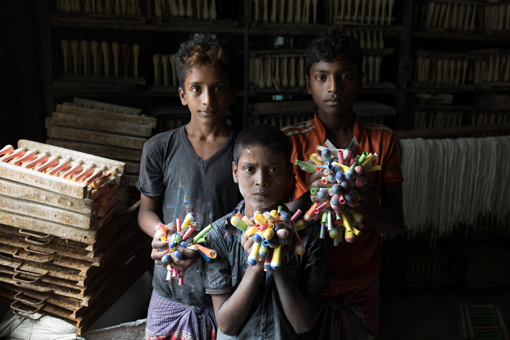 portrait photo of working children at a balloon factory in Bangladesh