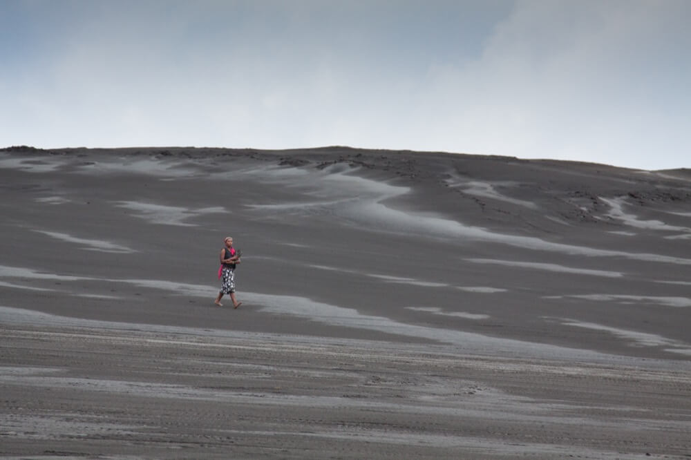 Person walking on dark sand